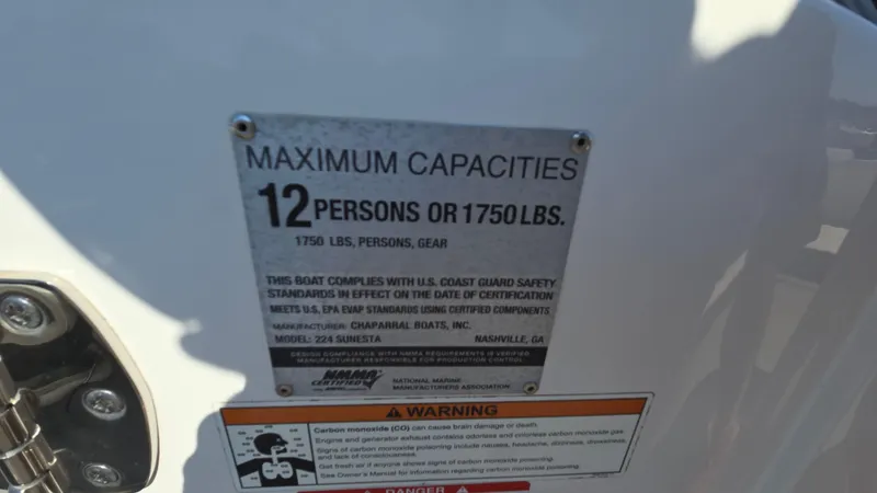Slide: The Image of 2018 Chaparral 224 Sunesta capacity plate, 12 persons or 1750 lbs, safety compliance details. - 49