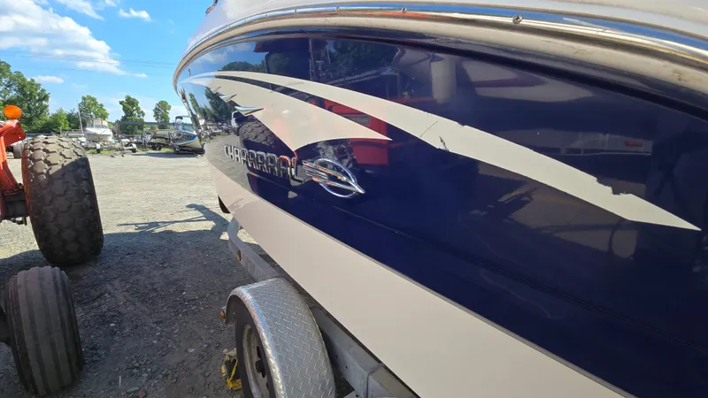 Slide: The Image of 2018 Chaparral 224 Sunesta boat on trailer, blue and white design, parked outdoors. - 5