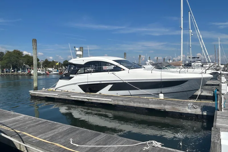 Slide: The Image of 2023 Beneteau Gran Turismo 41 yacht docked at marina under clear blue sky. - 14