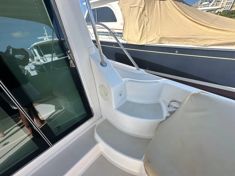 Slide: The Image of 2014 Back Cove 37 yacht deck with seating and railing, docked beside another boat. - 10