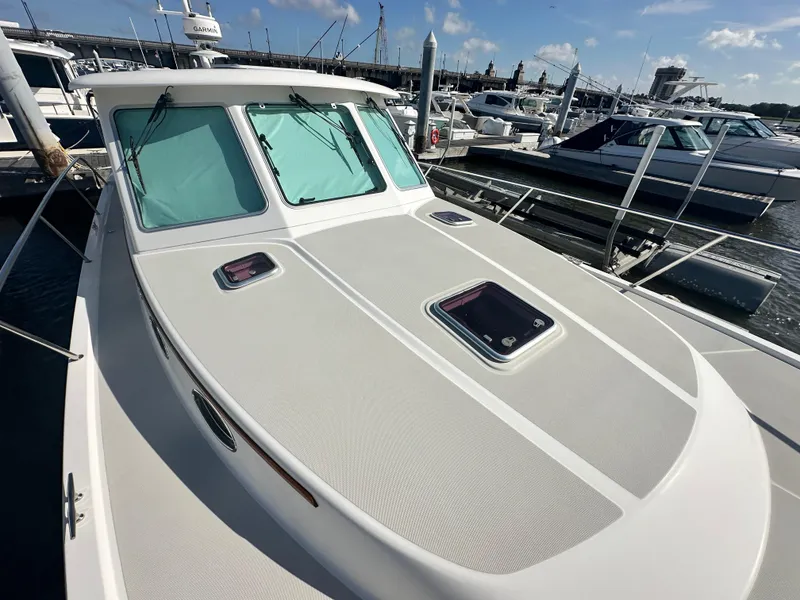 Slide: The Image of 2014 Back Cove 37 boat docked at marina, showcasing sleek design and windows. - 14