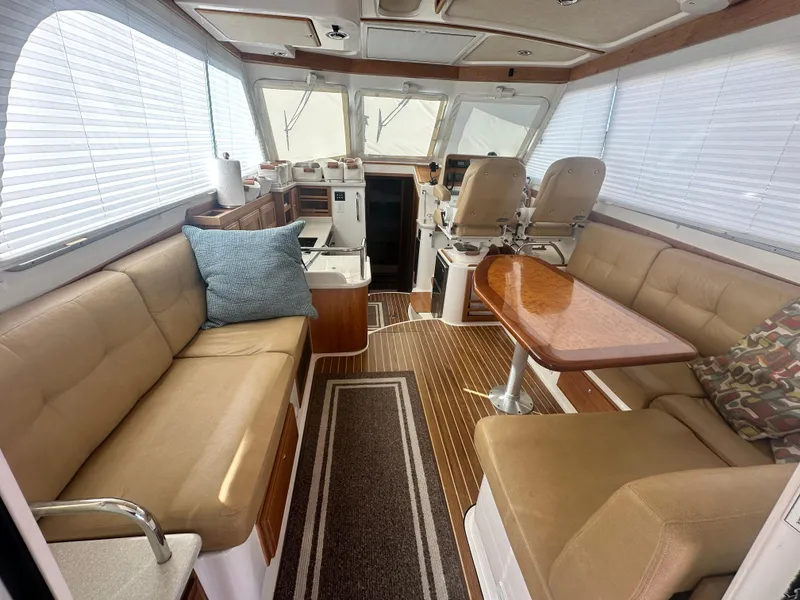 Slide: The Image of Interior of 2014 Back Cove 37 yacht with beige seating and wooden table. - 22