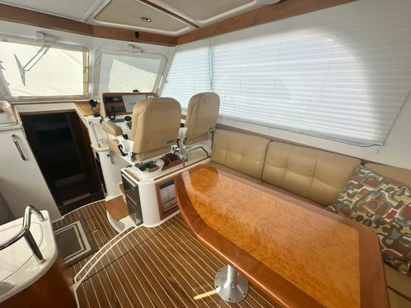 Slide: The Image of Interior of 2014 Back Cove 37 yacht with helm, seating, and wooden table. - 24