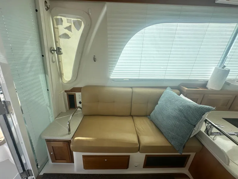 Slide: The Image of Interior of a 2014 Back Cove 37 boat with beige seating and blue cushion. - 25