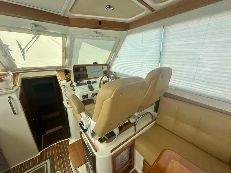 Slide: The Image of Interior of 2014 Back Cove 37 boat with helm, beige seating, and Garmin navigation system. - 28