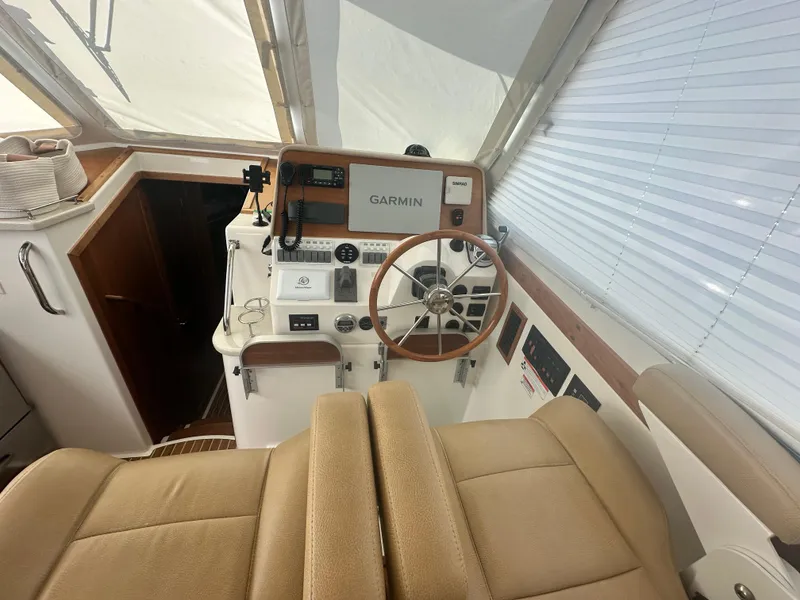 Slide: The Image of 2014 Back Cove 37 helm with Garmin navigation, beige seating, and wooden accents. - 29