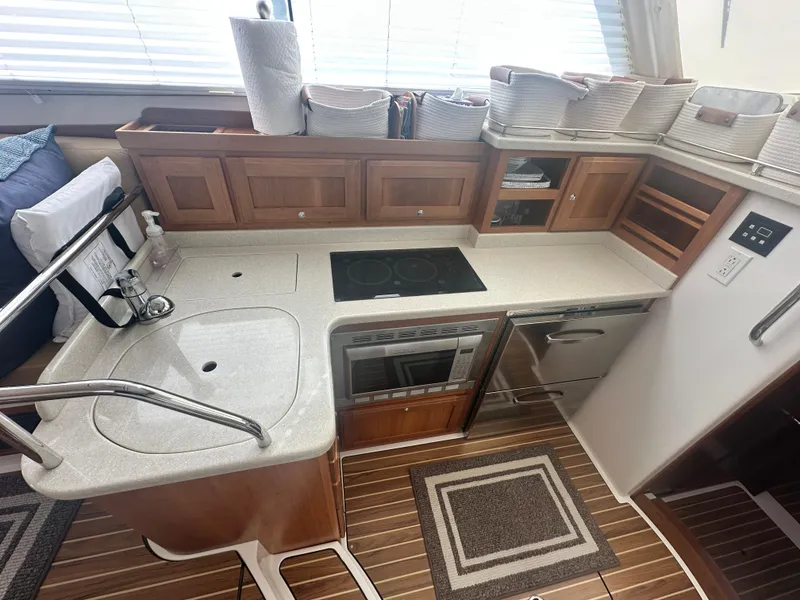 Slide: The Image of 2014 Back Cove 37 yacht kitchen with modern appliances, wooden cabinets, and countertop. - 30