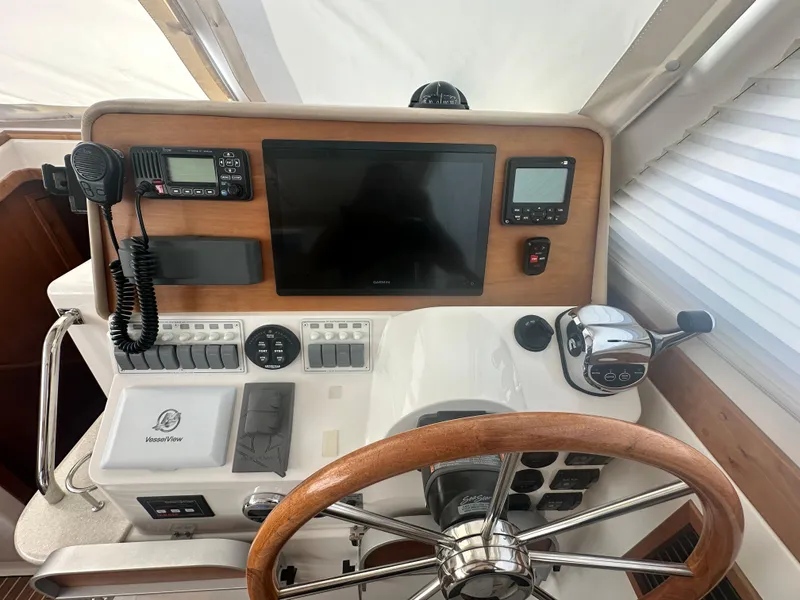 Slide: The Image of Helm of 2014 Back Cove 37 boat with steering wheel, controls, and navigation equipment. - 33