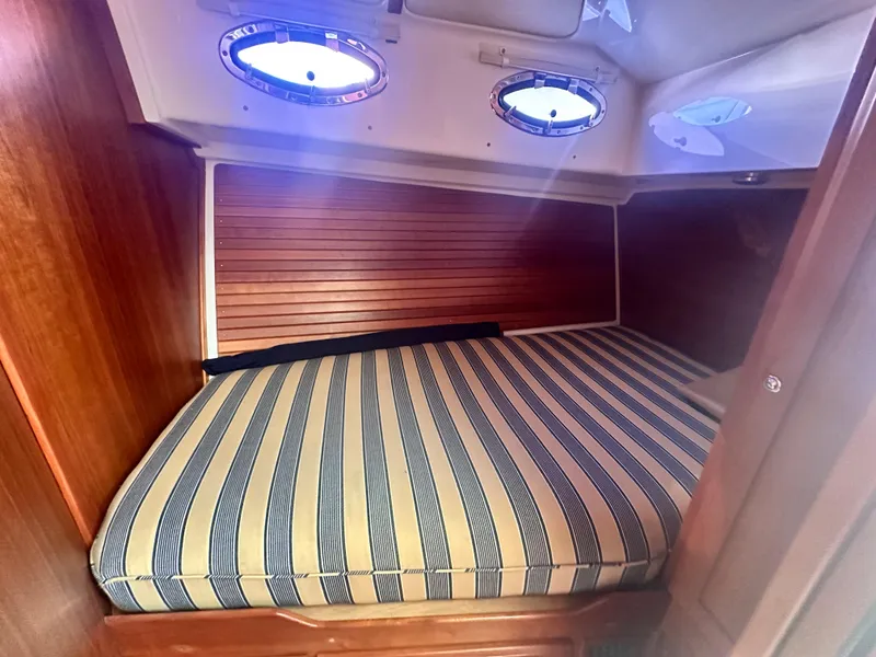 Slide: The Image of Cozy cabin interior of 2014 Back Cove 37 with striped bedding and portholes. - 45