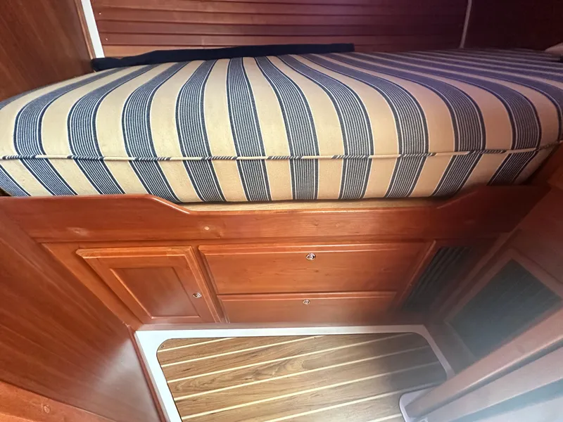 Slide: The Image of 2014 Back Cove 37 interior with striped cushion and wooden cabinetry. - 46