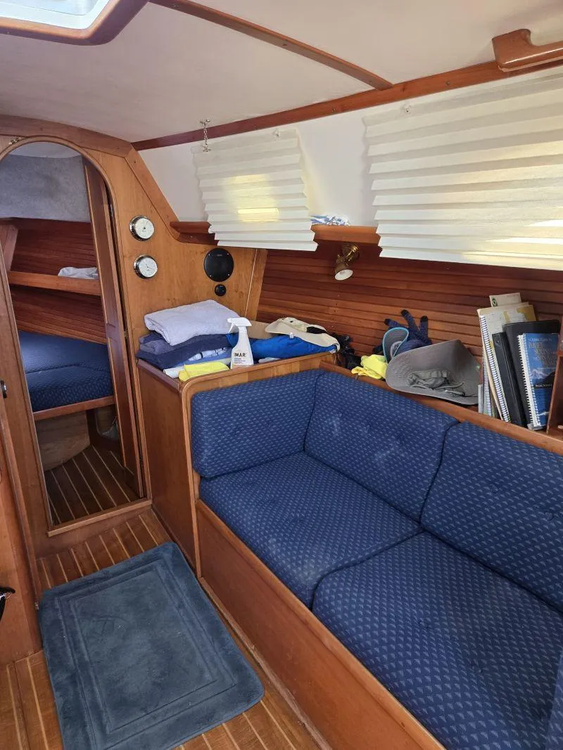 Slide: The Image of Interior of a 1993 Freedom Cruising Sloop with blue seating and wooden accents. - 11