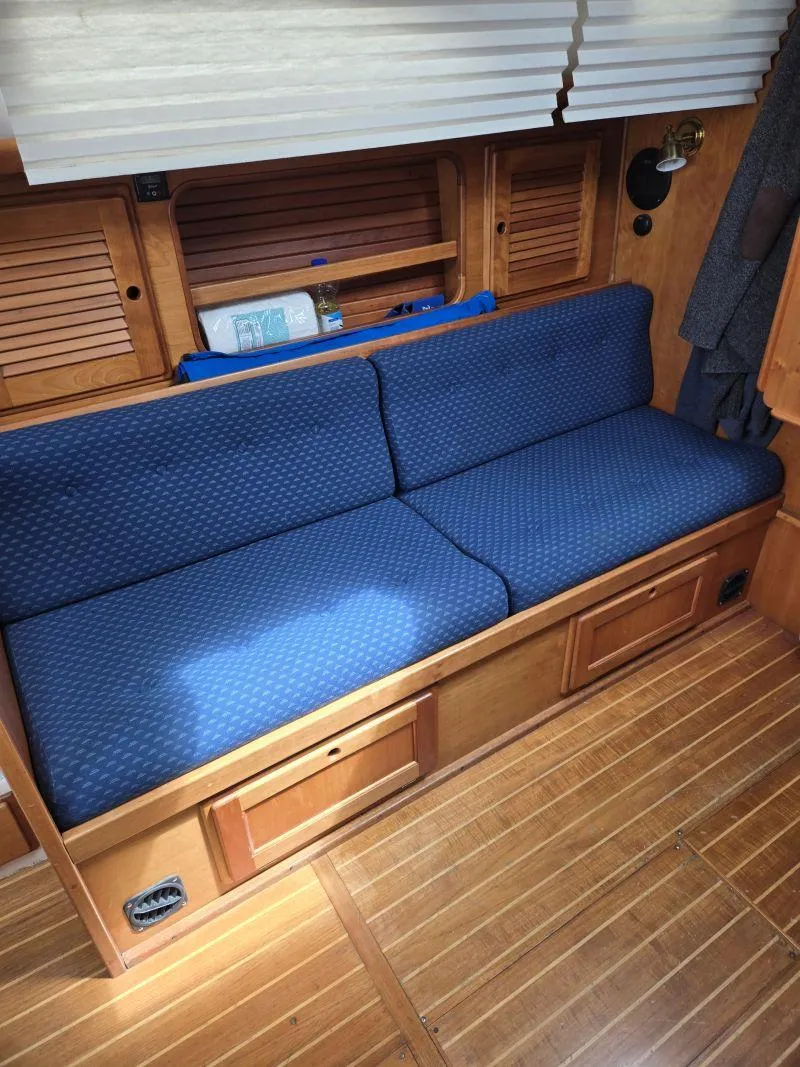 Slide: The Image of Blue cushioned seating in a 1993 Freedom Cruising sloop interior with wooden accents. - 19