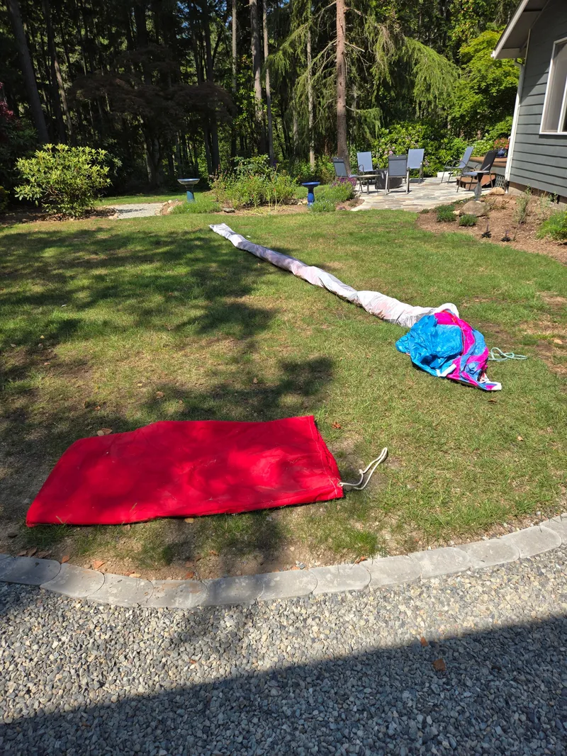 Slide: The Image of Outdoor scene with sail and red bag on grass, near patio furniture. - 22