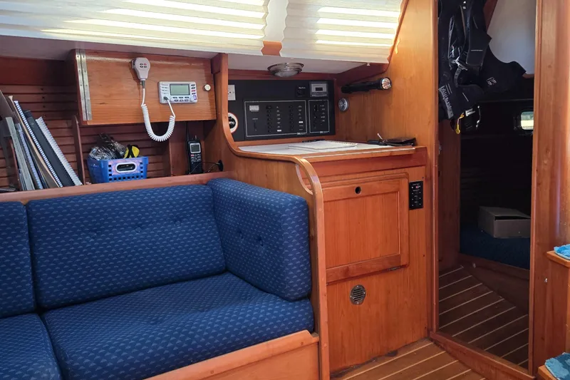 Slide: The Image of Interior of 1993 Freedom Cruising Sloop with blue seating and wooden cabinetry. - 34