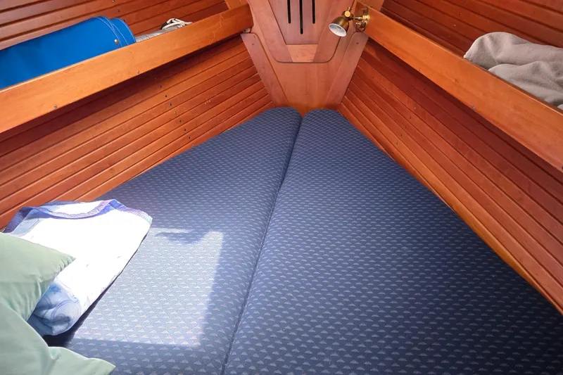 Slide: The Image of Cozy cabin interior of 1993 Freedom Cruising sloop with wooden paneling and blue bedding. - 35