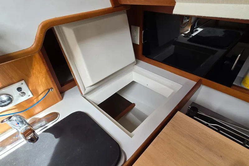 Slide: The Image of Interior of 1993 Freedom Cruising Sloop with open storage compartment and sink area. - 45