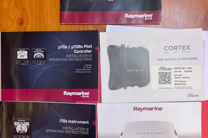 Slide: The Image of Instruction manuals for Raymarine and Vesper marine equipment on a wooden surface. - 48