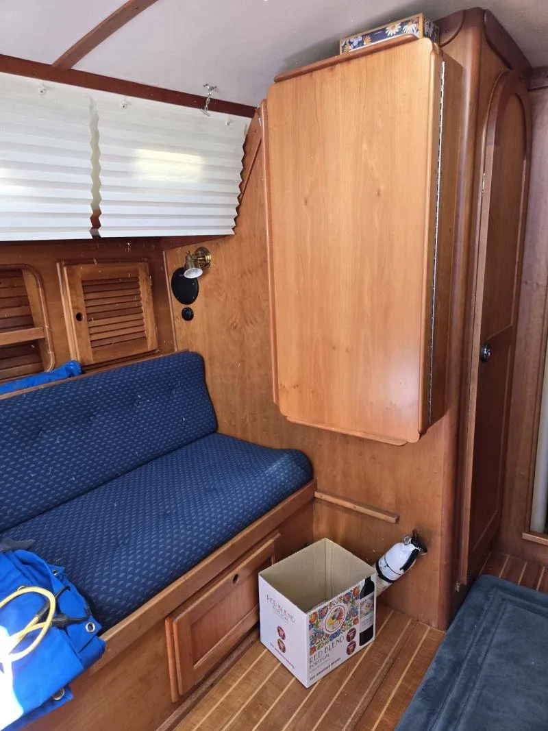 Slide: The Image of Interior of 1993 Freedom Cruising Sloop with blue seating and wooden cabinetry. - 7