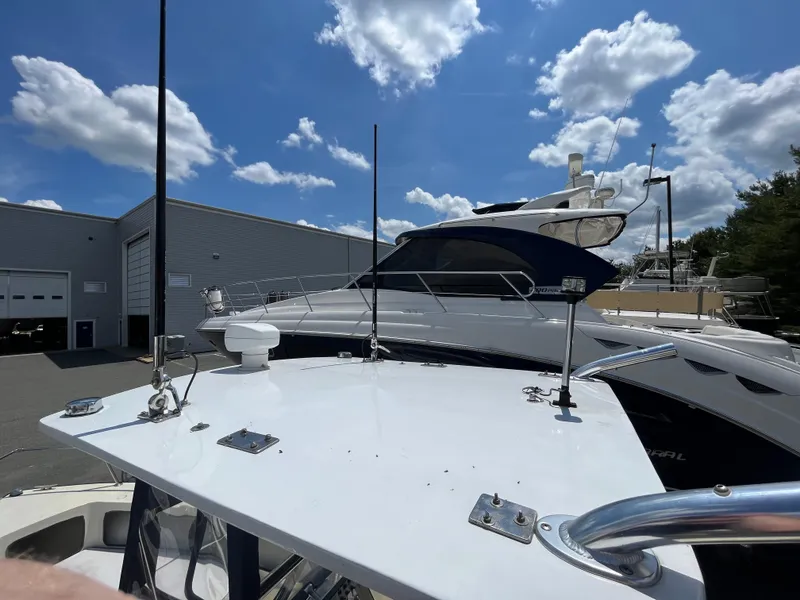 Slide: The Image of 1975 SeaCraft 20 Classic boat docked near a warehouse under a blue sky with clouds. - 4
