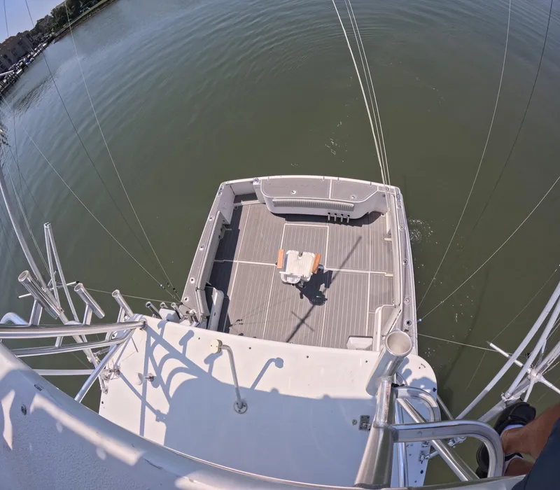 Slide: The Image of 2004 Stamas 370 Express boat deck view, featuring fishing chair and calm waters. - 12