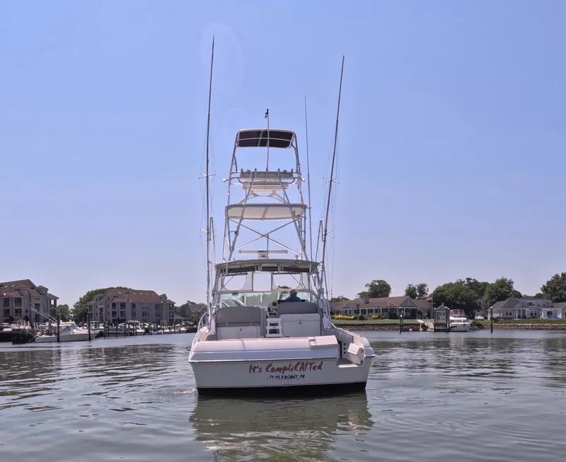 Slide: The Image of 2004 Stamas 370 Express boat on calm water, clear sky, residential backdrop. - 15