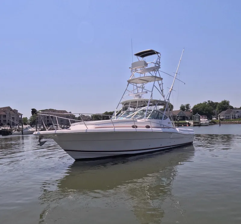 Slide: The Image of 2004 Stamas 370 Express boat on calm water, clear sky, residential backdrop. - 16