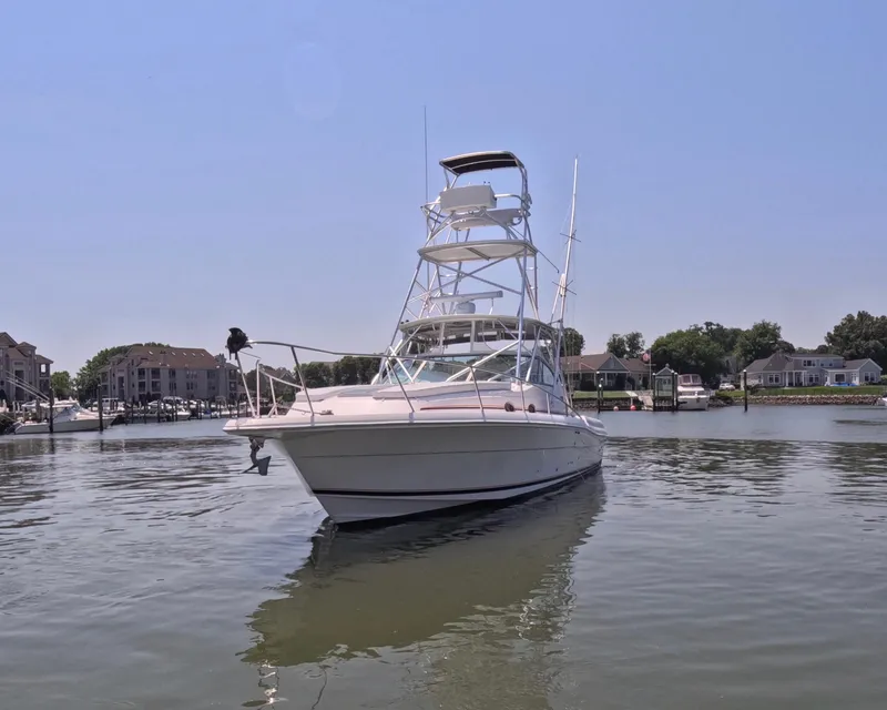 Slide: The Image of 2004 Stamas 370 Express boat on calm water near residential docks. - 17