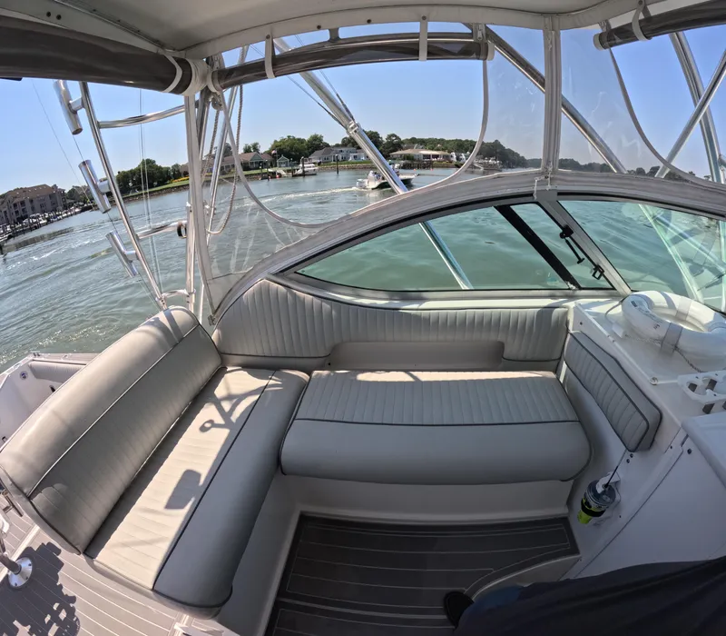 Slide: The Image of 2004 Stamas 370 Express boat interior with cushioned seating and waterfront view. - 2