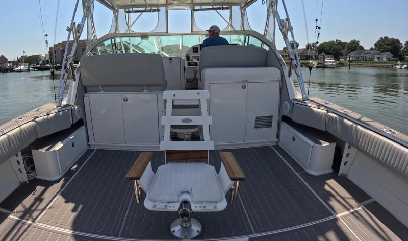 Slide: The Image of 2004 Stamas 370 Express boat interior with seating and fishing chair on calm water. - 4