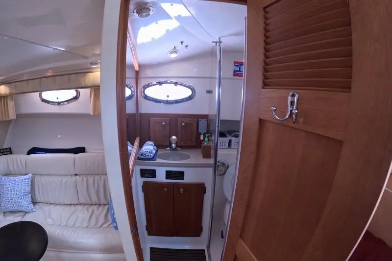 Slide: The Image of Interior of 2004 Stamas 370 Express yacht, featuring a cozy cabin and bathroom. - 9