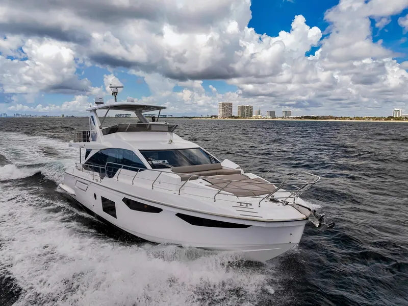Slide: The Image of 2022 Azimut Fly 60 yacht cruising on open water under a cloudy sky. - 0