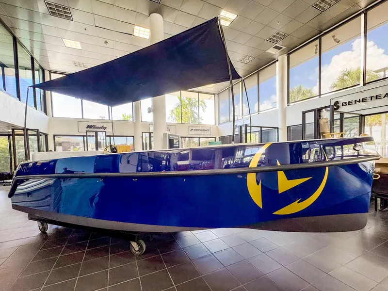 Slide: The Image of 2025 Vision Marine Technologies Volt 180 boat displayed indoors, featuring a sleek blue design. - 17
