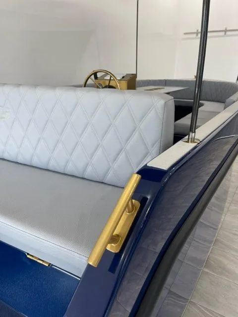 Slide: The Image of 2023 Vision Marine Technologies Volt 180 interior with elegant seating and gold accents. - 12