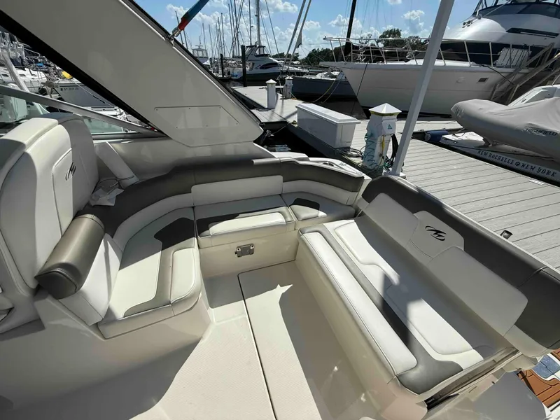 Slide: The Image of 2013 Monterey 280 SCR boat interior with white seating, docked at marina. - 2