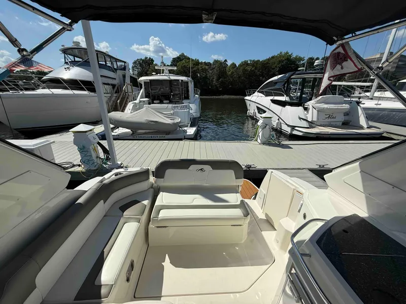Slide: The Image of 2013 Monterey 280 SCR boat interior at marina with docked yachts in background. - 3
