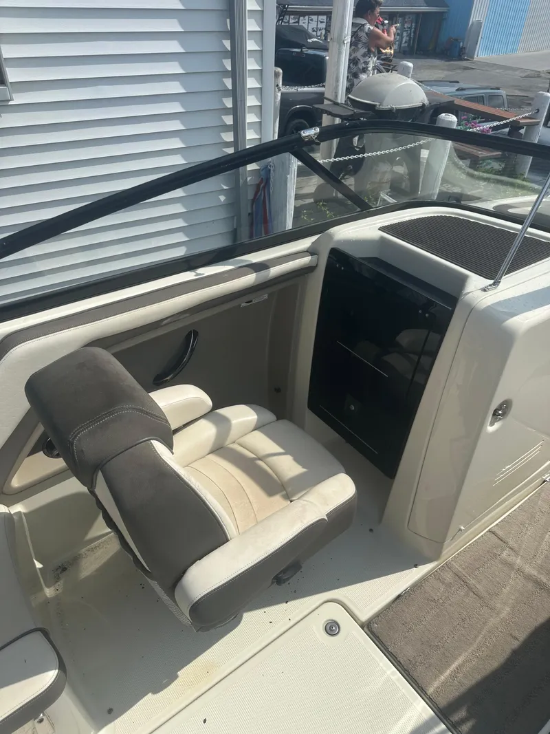 Slide: The Image of 2015 Yamaha Boats 242 Limited interior with beige seating and black dashboard. - 7