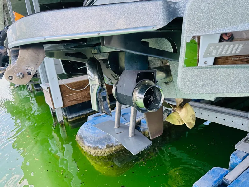 Slide: The Image of 2022 Malibu Wakesetter 24 MXZ boat propeller and rudder in green water. - 10