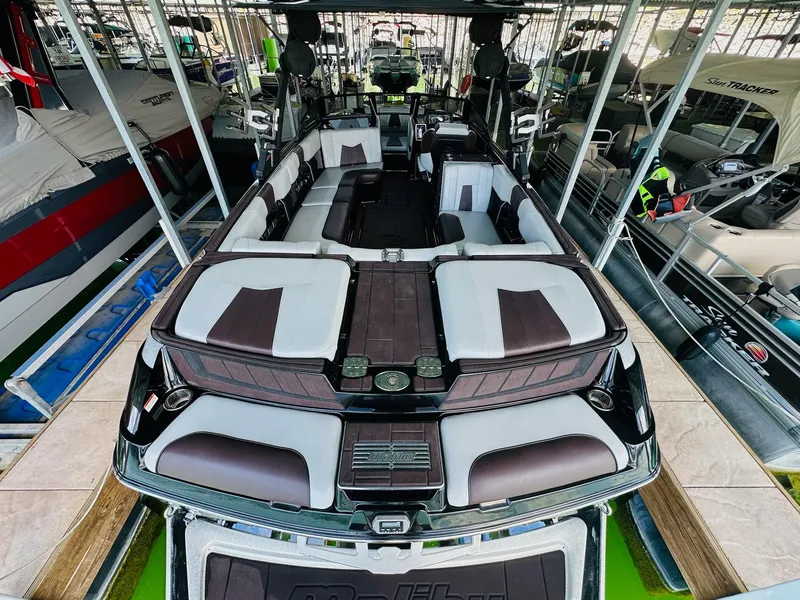 Slide: The Image of 2022 Malibu Wakesetter 24 MXZ boat with spacious seating, docked in a marina. - 11