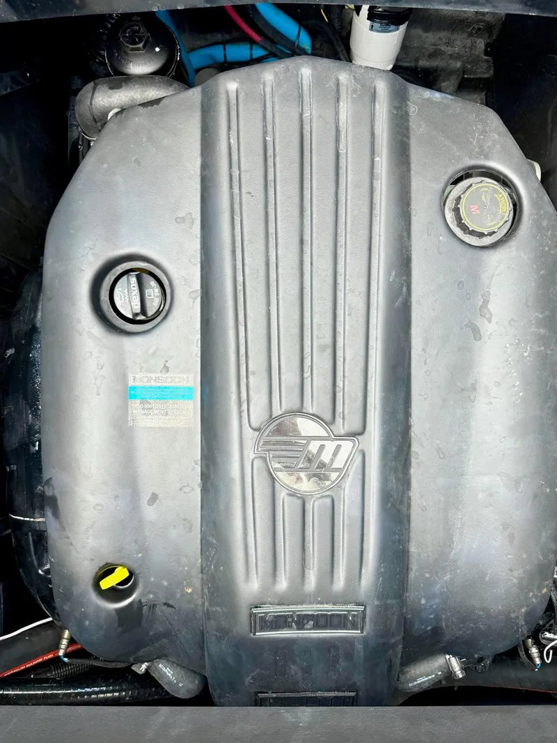 Slide: The Image of Engine of 2022 Malibu Wakesetter 24 MXZ boat, featuring a sleek black cover. - 20