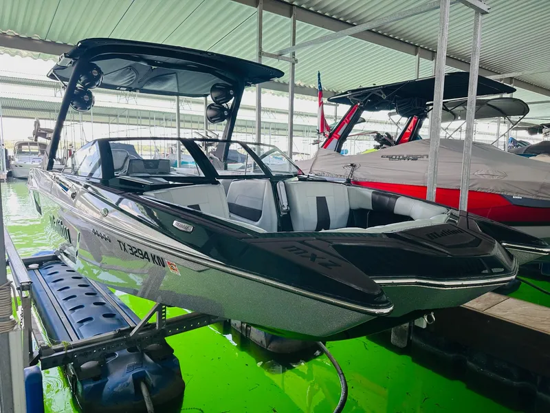 Slide: The Image of 2022 Malibu Wakesetter 24 MXZ boat docked in a covered marina. - 7