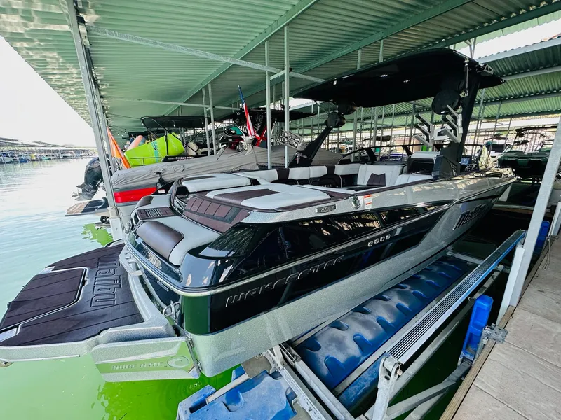 Slide: The Image of 2022 Malibu Wakesetter 24 MXZ boat docked in a covered marina. - 8