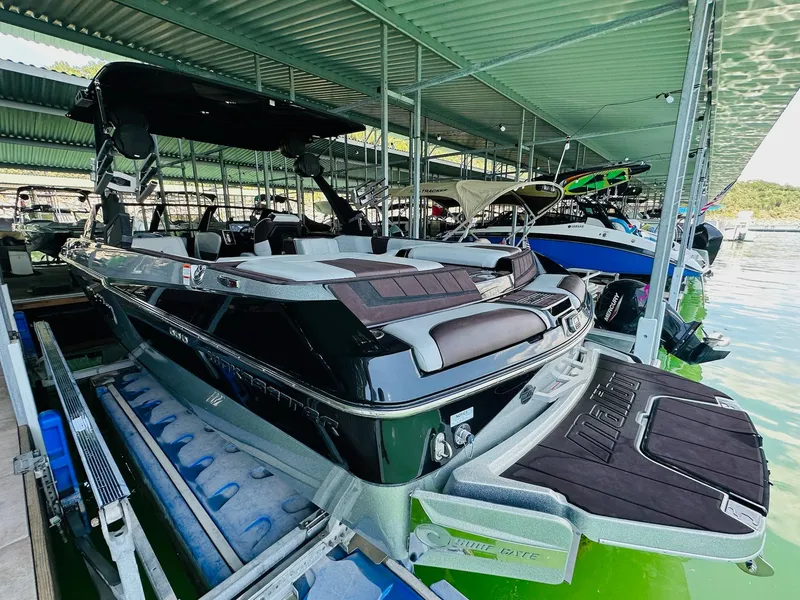 Slide: The Image of 2022 Malibu Wakesetter 24 MXZ boat docked in a covered marina. - 9