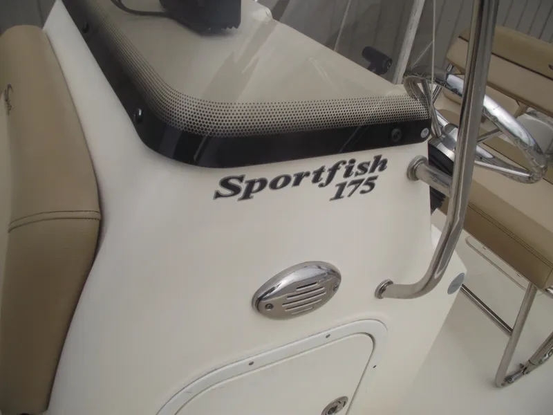 Slide: The Image of 2018 Scout 175 Sportfish boat console with beige seating and chrome details. - 12