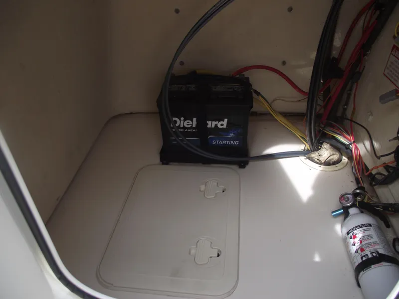 Slide: The Image of 2018 Scout 175 Sportfish battery compartment with DieHard battery and fire extinguisher. - 14