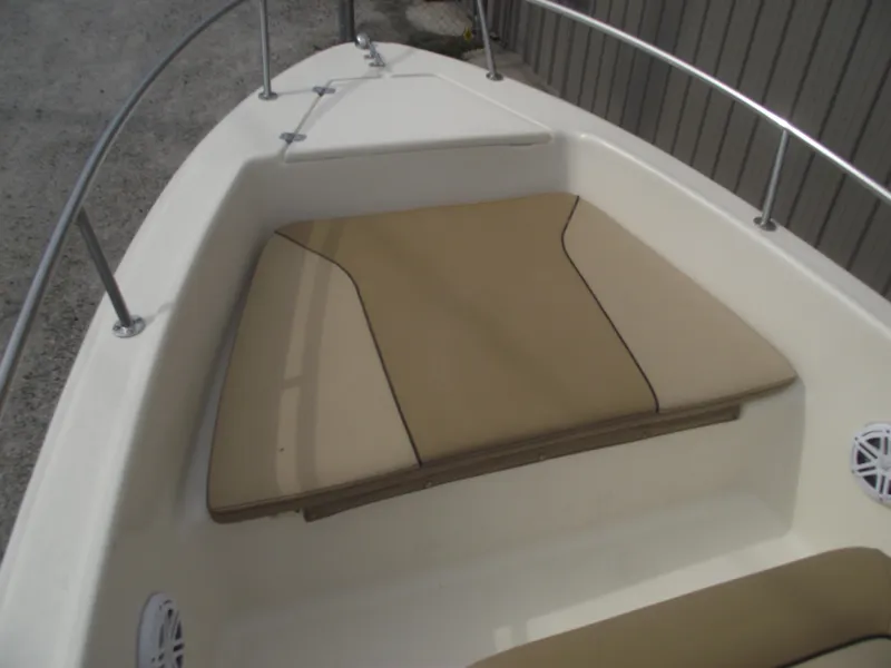 Slide: The Image of 2018 Scout 175 Sportfish boat interior with tan cushioned seating and stainless steel railings. - 7