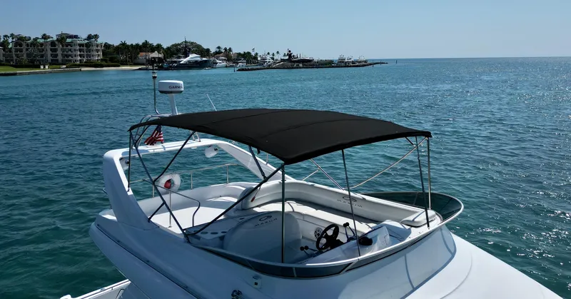 Slide: The Image of 1999 Maxum 4600 SCB yacht on calm blue waters near a coastal town. - 1