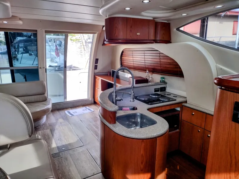 Slide: The Image of Interior of 1999 Maxum 4600 SCB yacht with modern kitchen and seating area. - 10