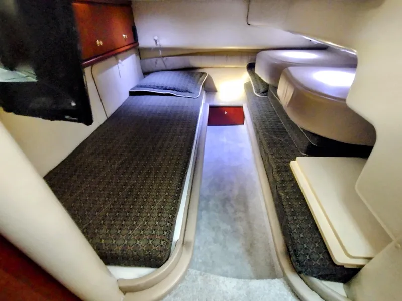 Slide: The Image of 1999 Maxum 4600 SCB cabin interior with twin beds and storage cabinets. - 13