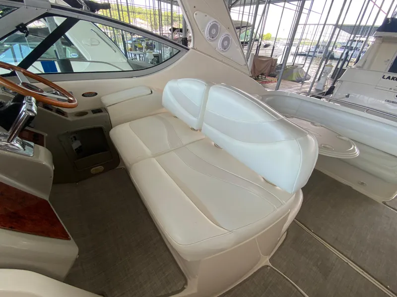 Slide: The Image of 1998 Maxum 3700 SCR boat interior with white leather seating and wooden steering wheel. - 11