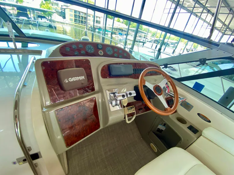 Slide: The Image of 1998 Maxum 3700 SCR boat helm with Garmin navigation, wood accents, and steering wheel. - 12